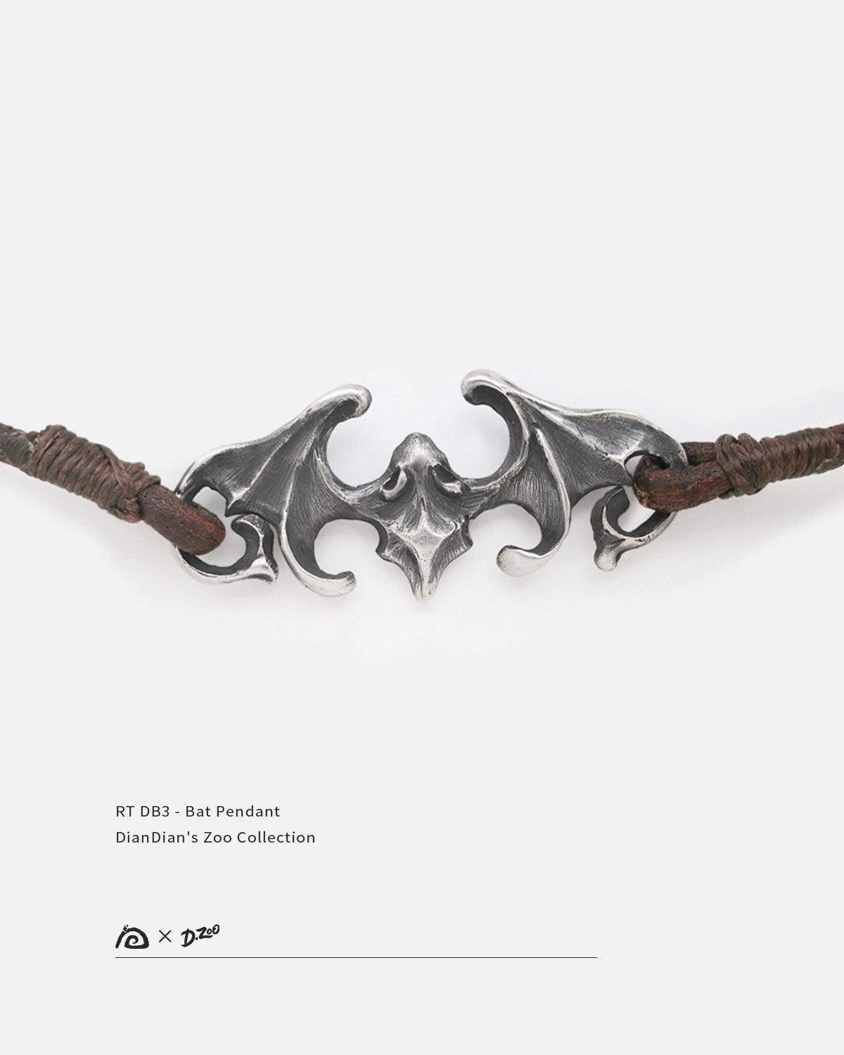 Front view of an aged 990 fine silver bat pendant with sculpted wings and dark oxidized finish, by Dzoo, at Rainbow Tears.