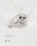 Front view of 925 sterling silver Ploop seal pendant with black cubic zirconia eyes on white velvet, by Dzoo, at Rainbow Tears.