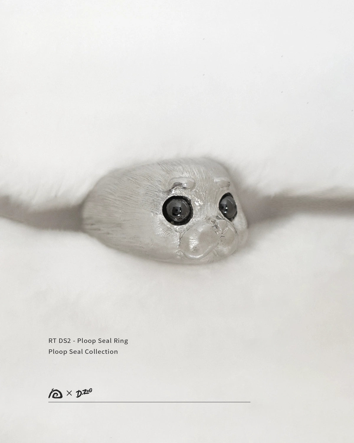 A 45-degree view of the 925 sterling silver Ploop seal ring on a white blanket, by Dzoo, available at Rainbow Tears.