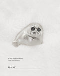 Front view of 925 sterling silver Ploop seal brooch with black cubic zirconia eyes on white velvet, by Dzoo, at Rainbow Tears.