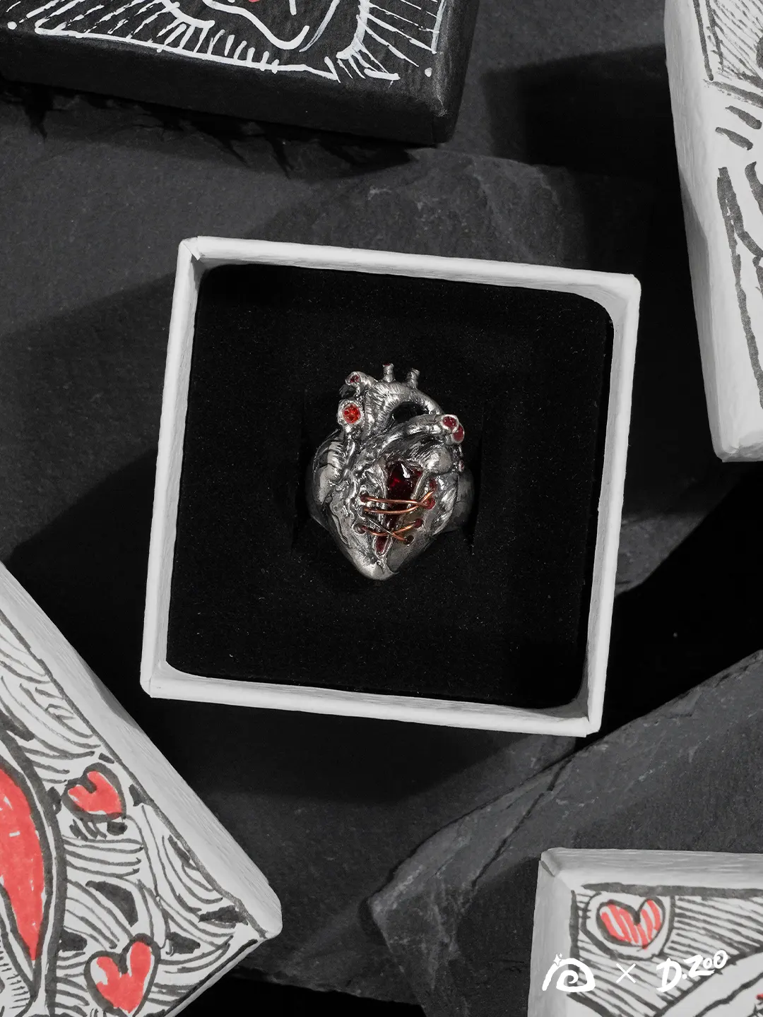 A heart ring displayed inside a jewelry box, surrounded by four hand-drawn heart-themed accessory boxes used as decorative elements.
