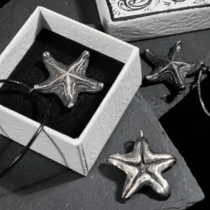 Three oxidized silver starfish pendants displayed with a hand-drawn starfish jewelry box, showcasing the vintage starfish necklace design.