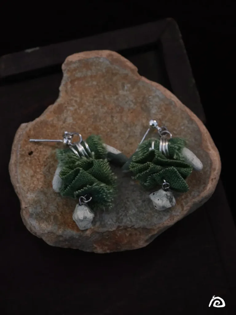 Handmade blue-and-white porcelain earrings, longhorn-shaped, with green plant-dyed fabric and irregular octahedron porcelain accents