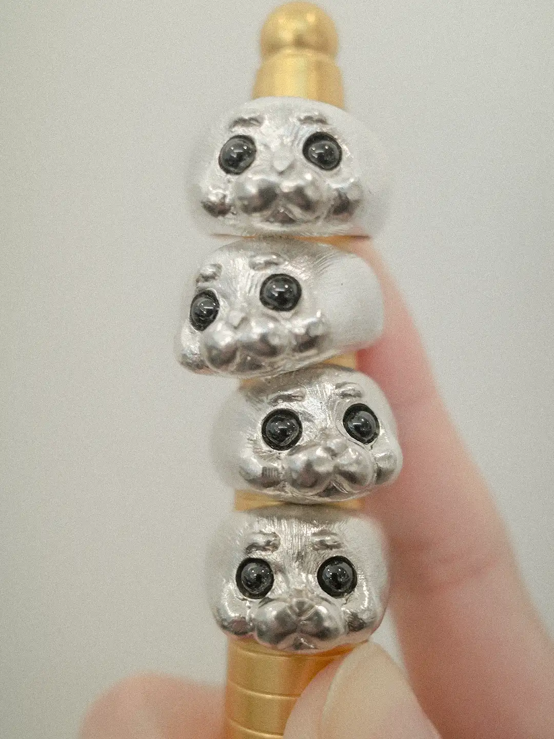 Four seal rings stacked on a ring mandrel showing their playful design