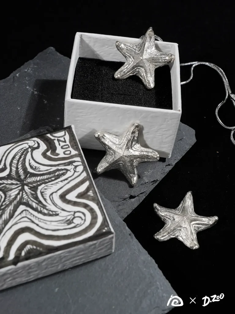 Three bright silver starfish pendants displayed with a hand-drawn starfish jewelry box.