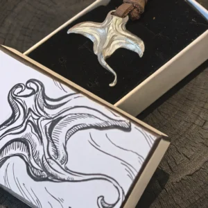 Manta ray necklace with leather cord placed inside a hand-painted jewelry box