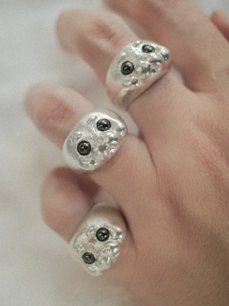 The round seal head and black zircon eyes on the woman's finger are visible through the 925 silver Ploop seal ring.