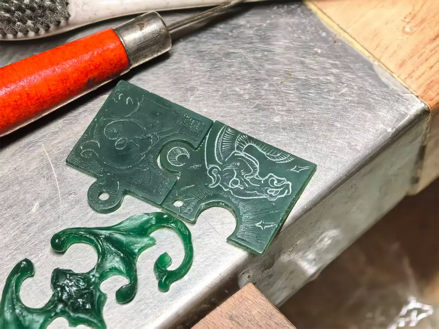 Wax models of custom puzzle pendants and a bat necklace prepared for lost wax casting