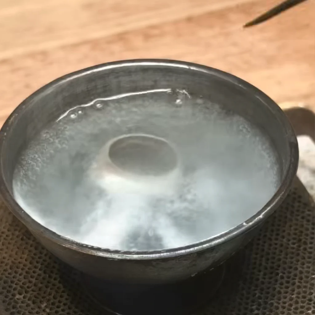 Boiling and whitening process of a sterling silver owl ring in jewelry workshop