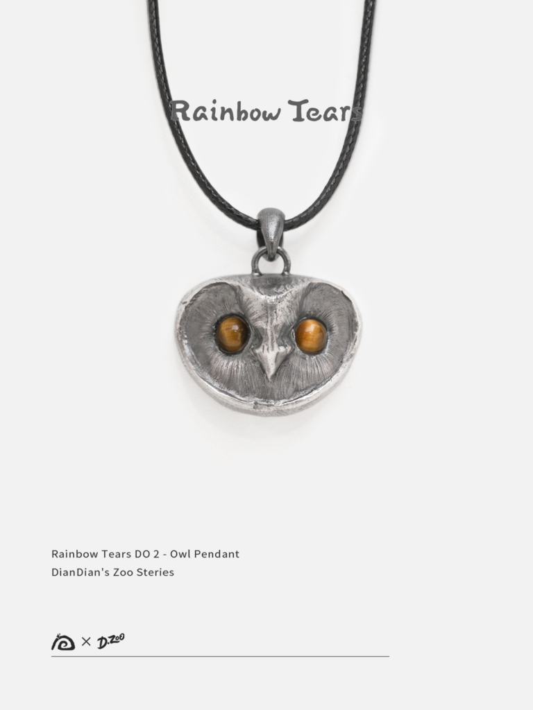 Front view of a sterling silver owl pendant with tiger's eye stone eyes on a white background