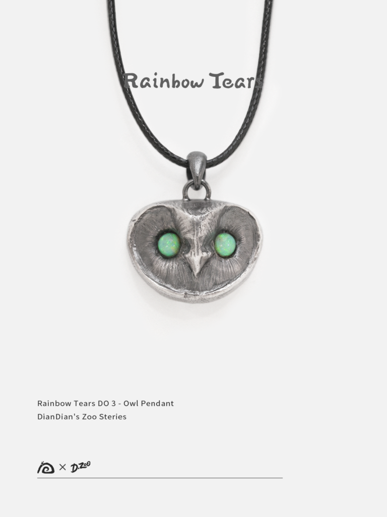 Front view of a handcrafted owl necklace with opal eyes on a white background