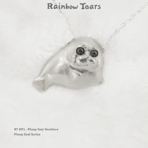 Front view of the Ploop seal necklace on white velvet