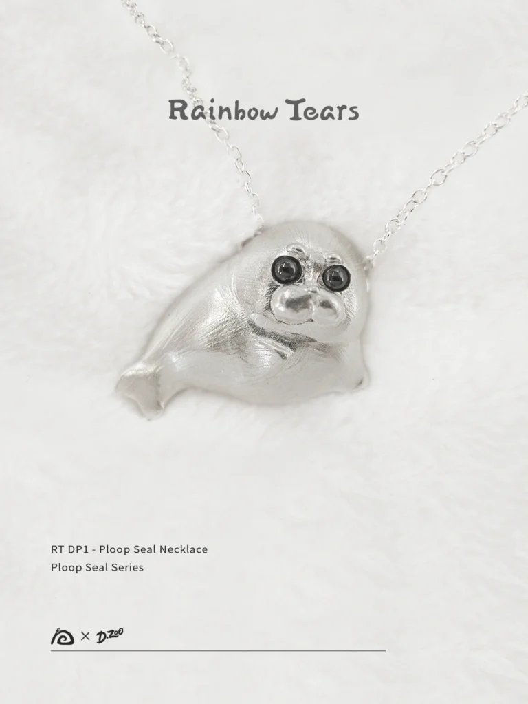 Front view of the Ploop seal necklace on white velvet