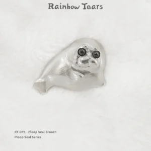 Front view of the pure silver Ploop seal brooch placed on white velvet