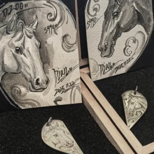 A pair of 990 fine silver half heart pendants with horse patterns, displayed alongside two exquisitely hand-painted horse art cards.