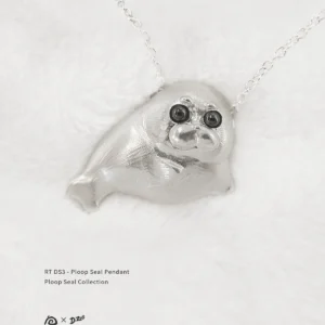 Front view of the Ploop seal pendant on white velvet