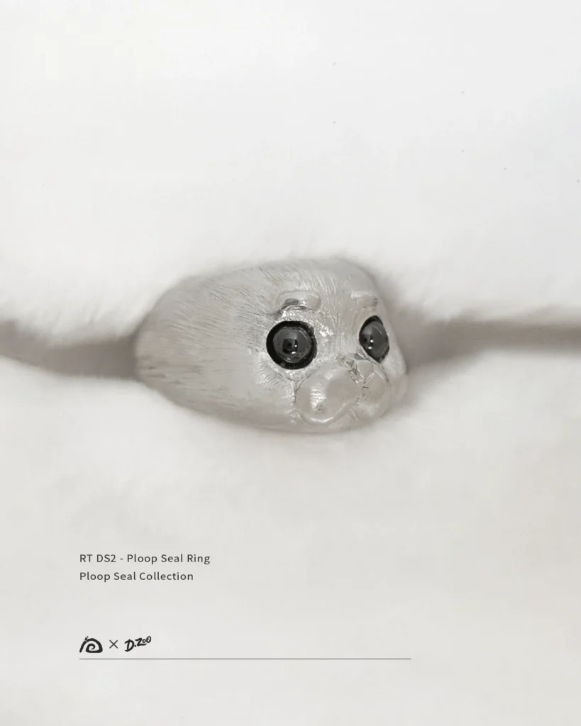 The pure silver Ploop seal ring is placed on a white blanket at a 45-degree angle.