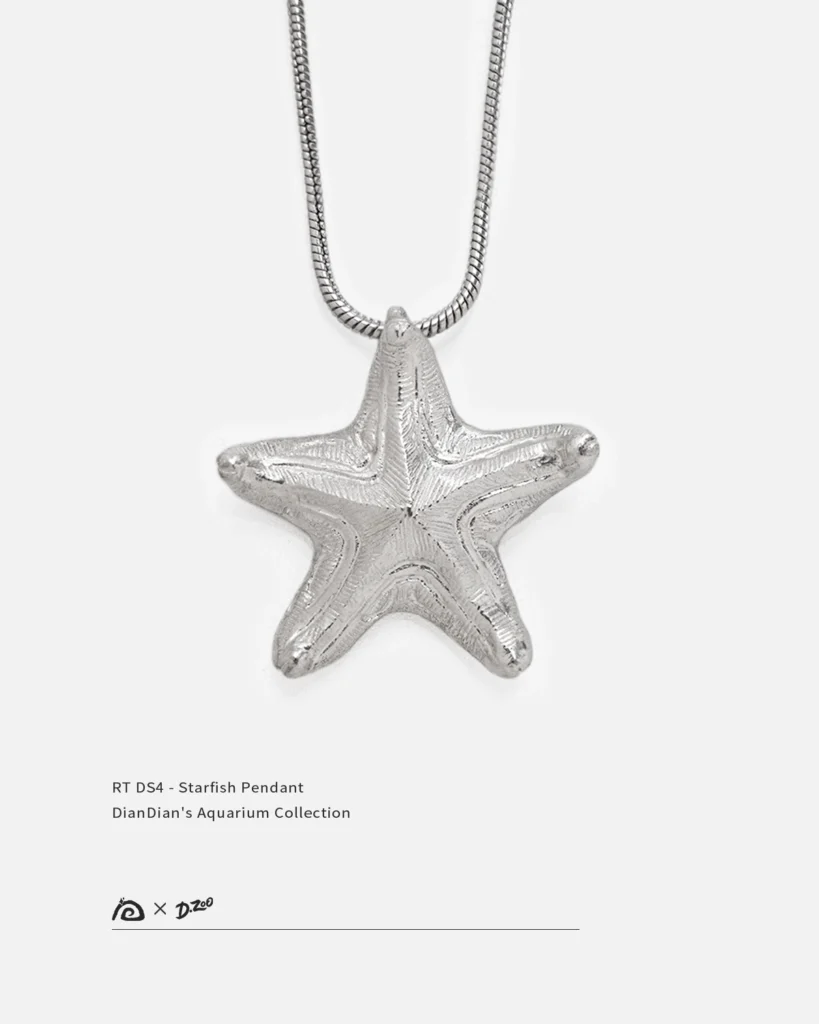 Front view of a bright handcrafted silver starfish pendant on a white background