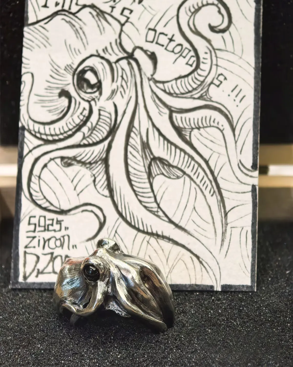 Octopus ring displayed with a designer's hand-drawn illustration card on the product page