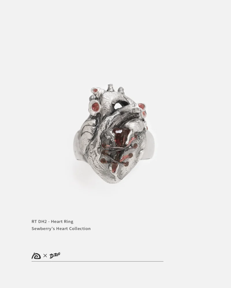 Front view of a sterling broken silver heart ring set with red zircon on a white background
