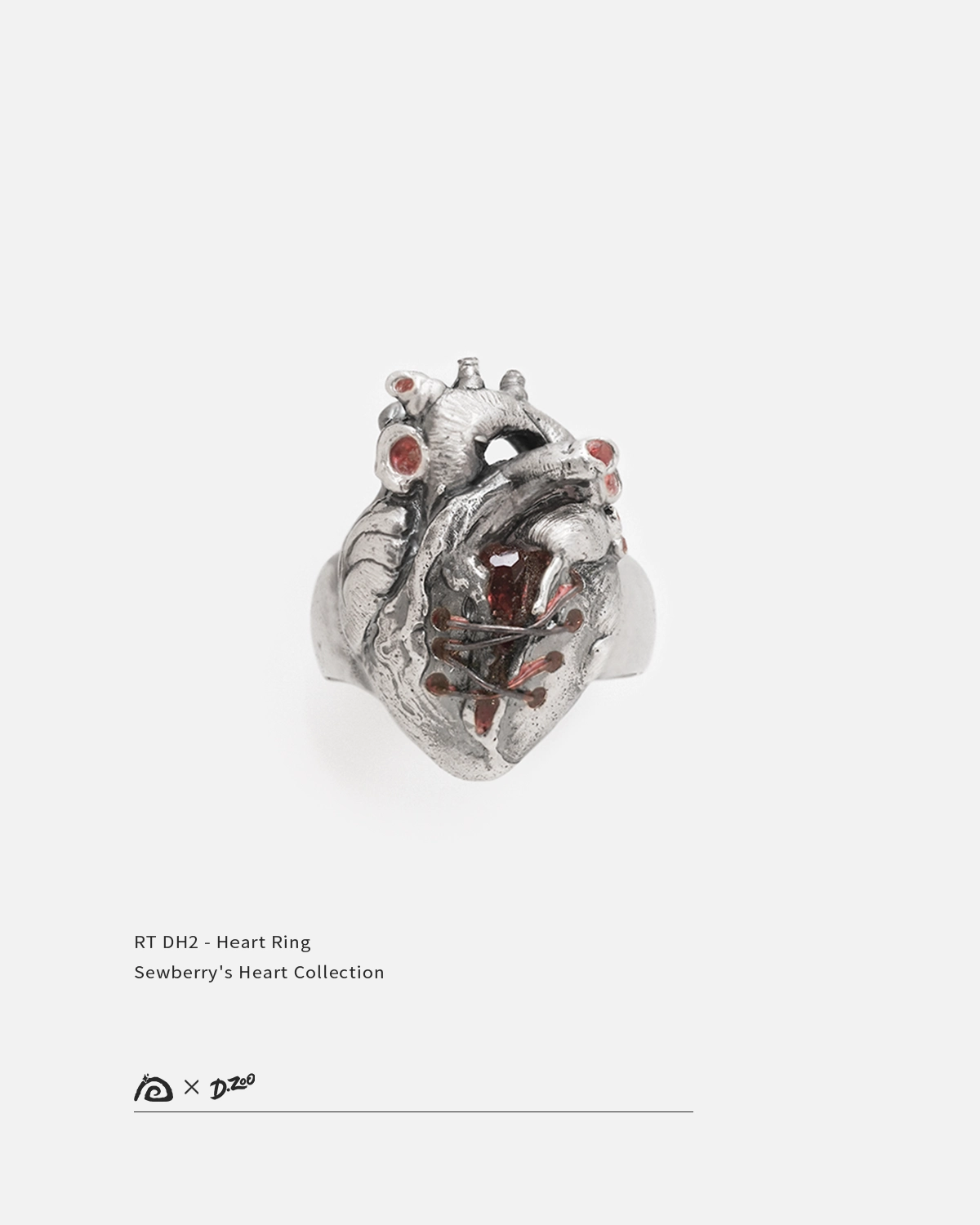 Front view of a sterling broken silver heart ring set with red zircon on a white background