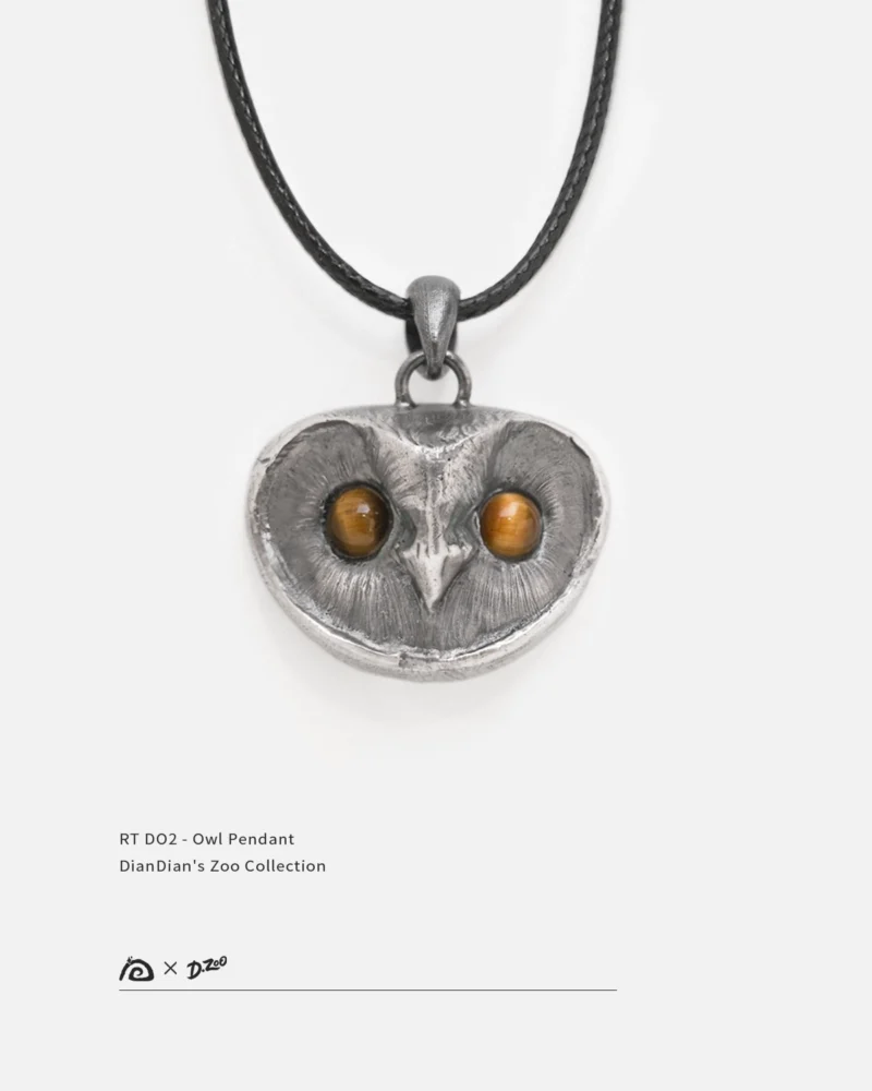 Front view of a sterling silver owl pendant with tiger's eye stone eyes on a white background