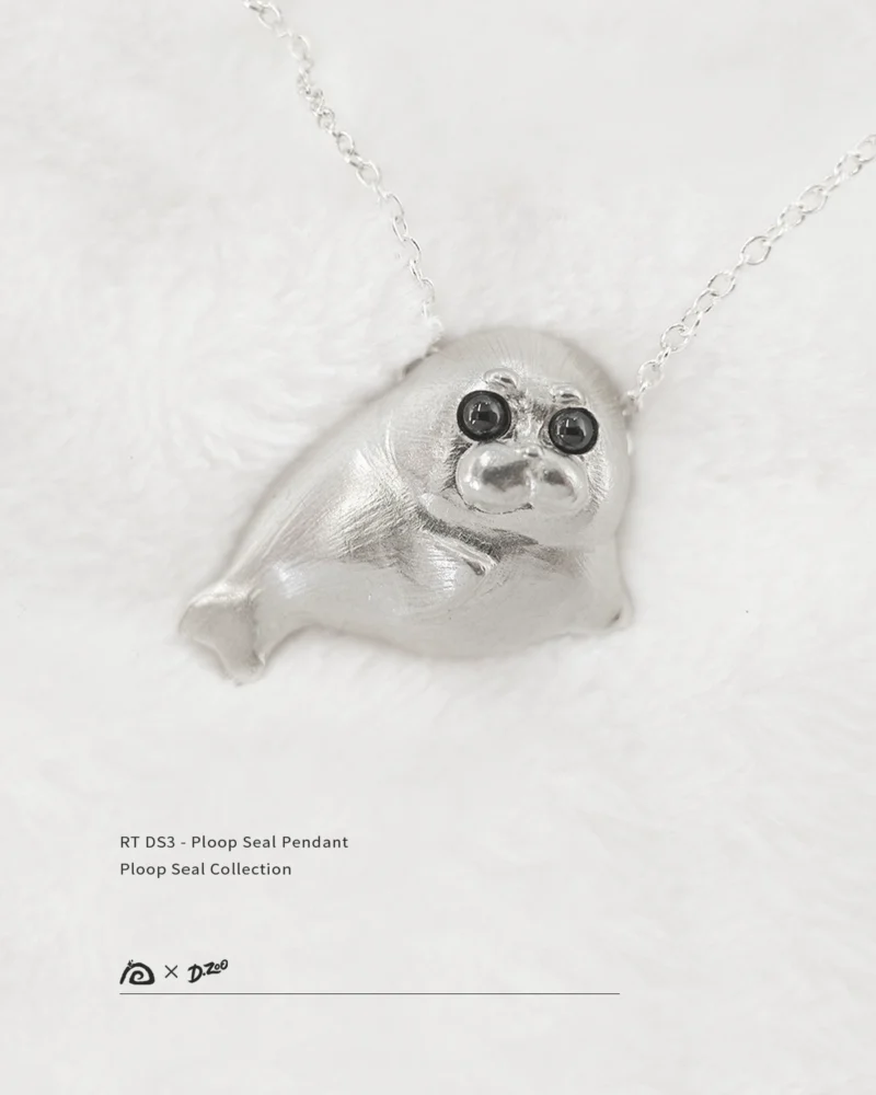Front view of the Ploop seal pendant on white velvet